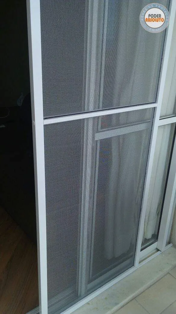Tela mosquiteira instalada em porta de sacada protegendo contra insetos.